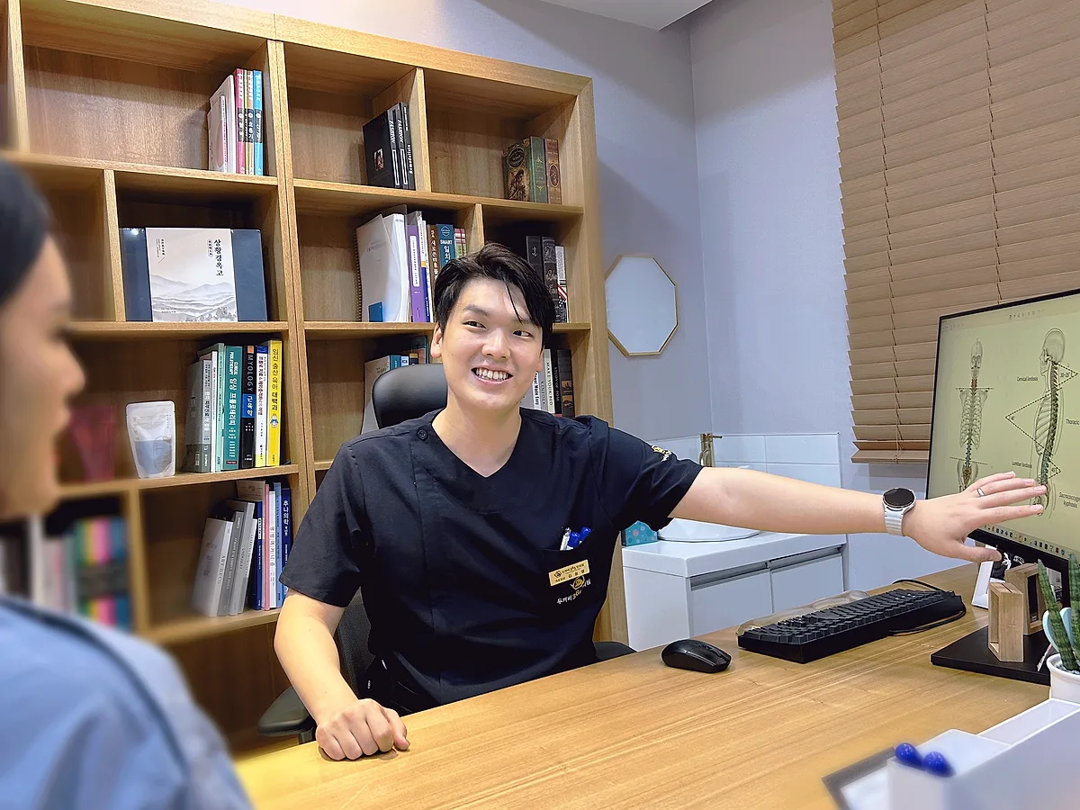 진료실에서 척추 모니터로 상태를 설명하는 김동영 원장